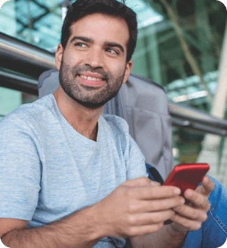 Homem sorrindo utilizando o celular